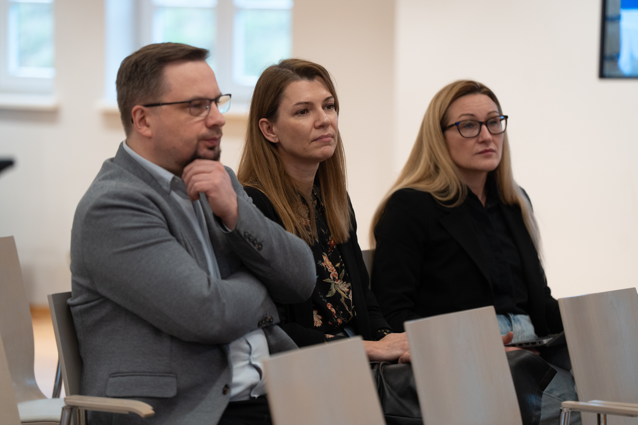 Od lewej Mirosław Zucholl - Zastępca Dyrektora Departamentu Europejskiego Funduszu Społecznego UMWP oraz dwie kobiety słuchają prezentacji