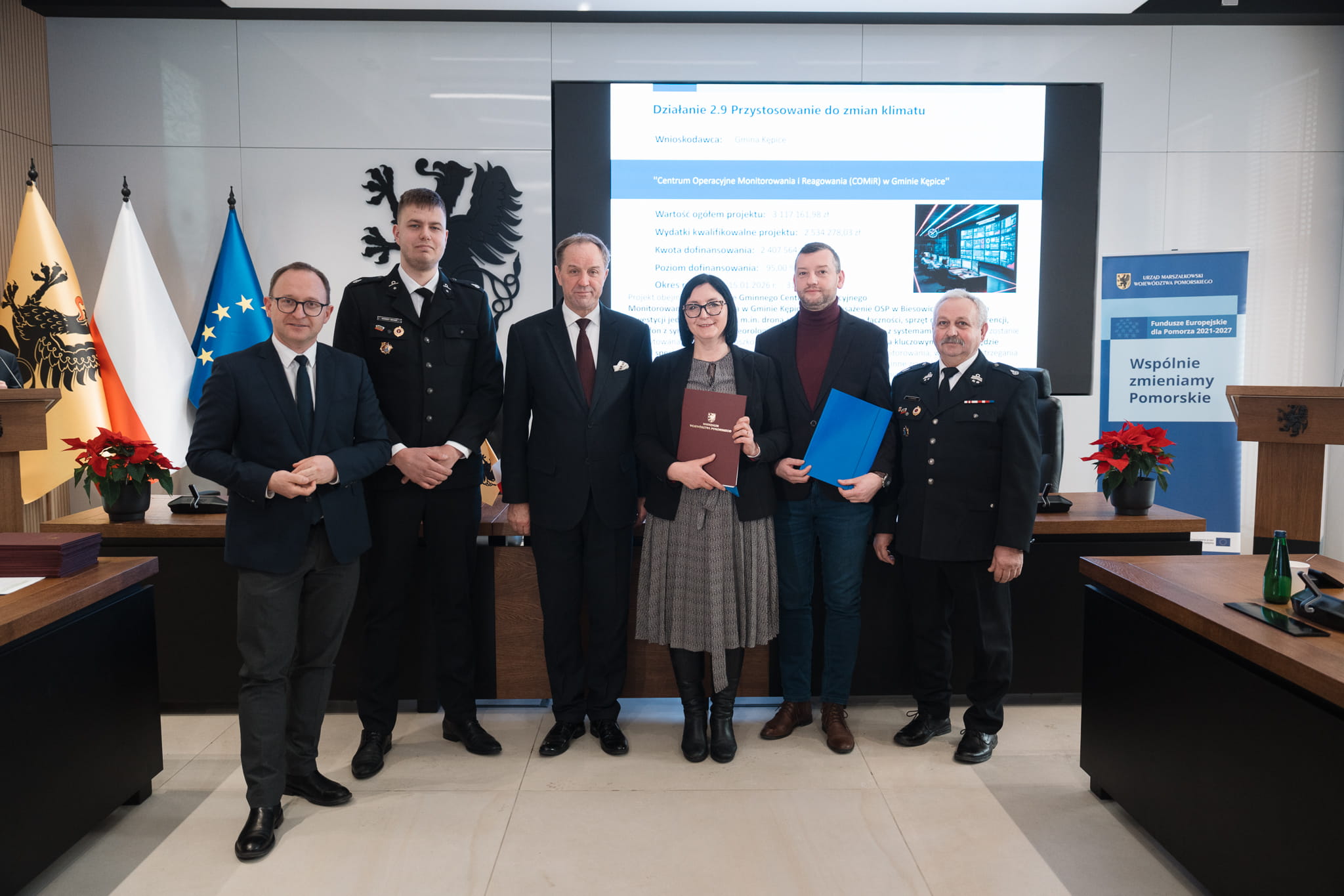 Grupa osób prezentuje podpisaną Umowę