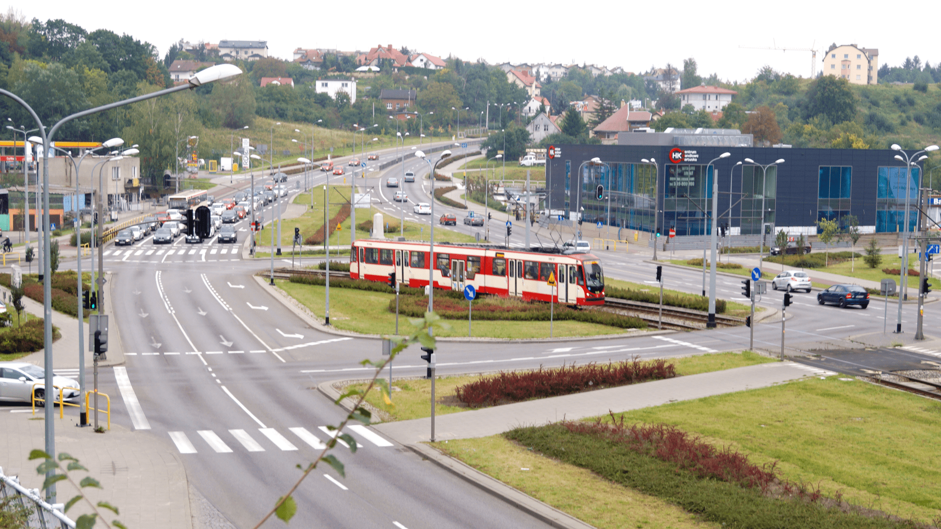 Czerwony tramwaj na środku dużego skrzyżowania