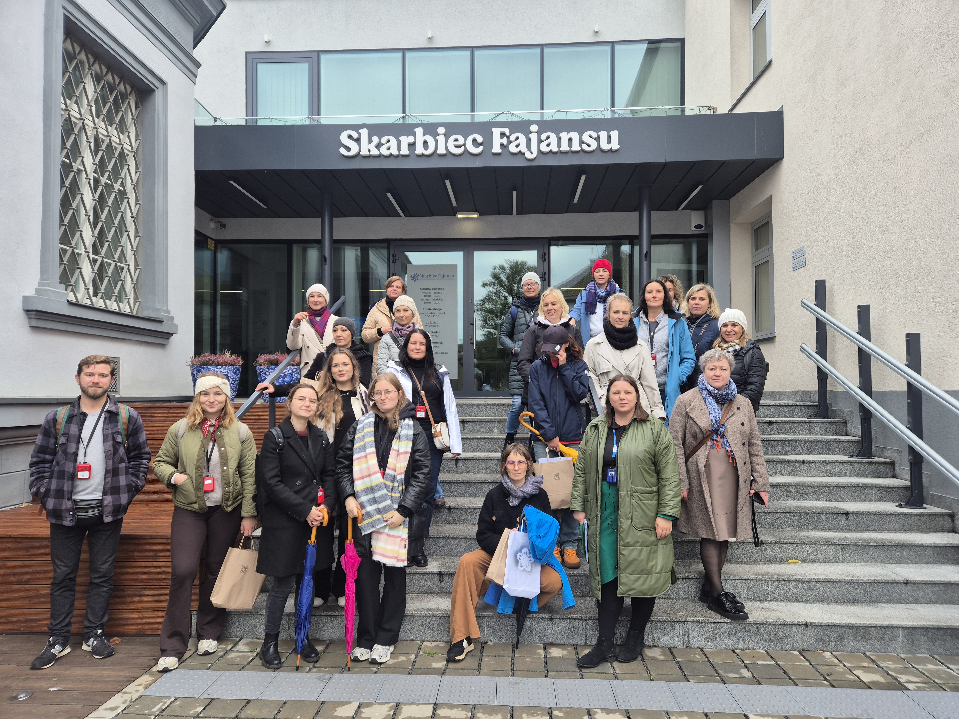 Grupa ludzi na schodach przed wejściem do skarbca fajansu