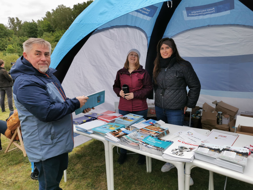 Dwie kobiety w namiocie rozmawiają z mężczyzną