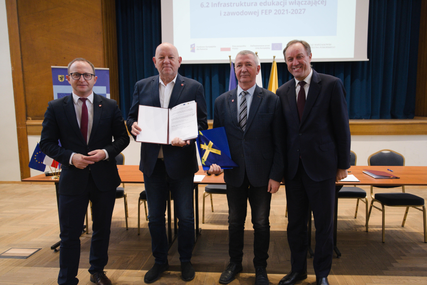 Marszałek Mieczysław Struk, wicemarszałek Marcin Skwierawski i dwie inne osoby prezentują podpisaną umowę