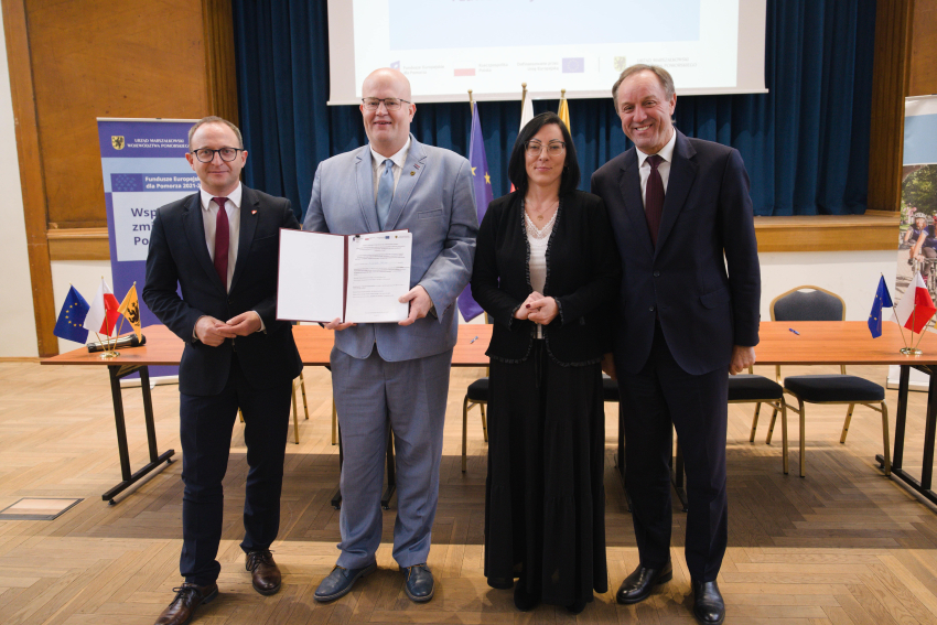 Marszałek Mieczysław Struk, wicemarszałek Marcin Skwierawski i dwie inne osoby prezentują podpisaną umowę