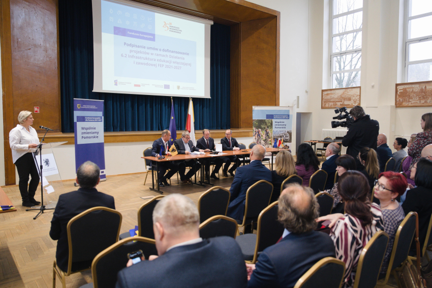 Martyna Sawicka, kierownik Departamentu Programów Regionalnych przemawia do zebranych z mównicy. Przy stole prezydialnym siedzą: marszałek Mieczysław Struk, wicemarszałek Marcin Skwierawski oraz dwie inne osoby