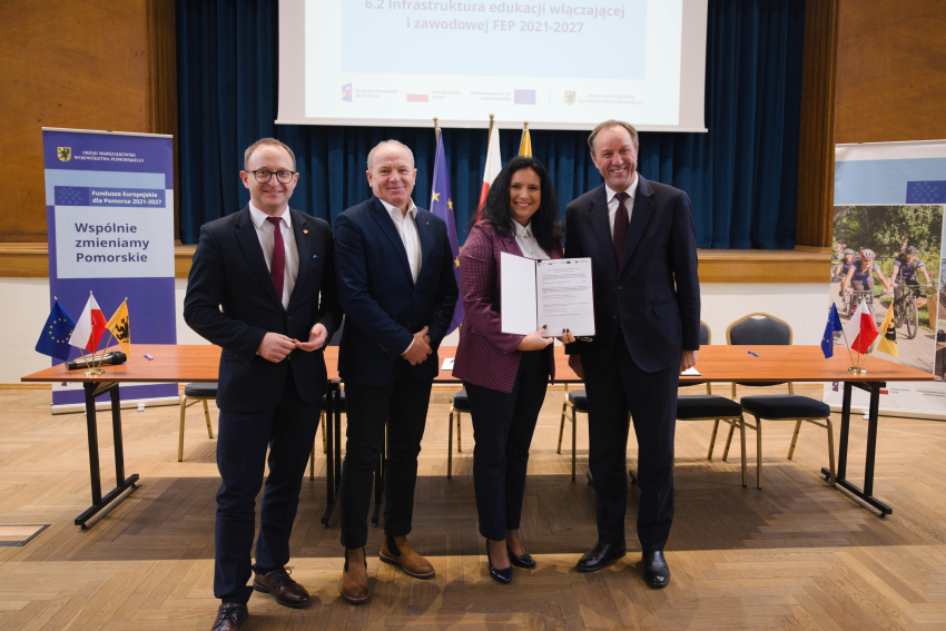 Marszałek Mieczysław Struk, wicemarszałek Marcin Skwierawski i dwie inne osoby prezentują podpisaną umowę