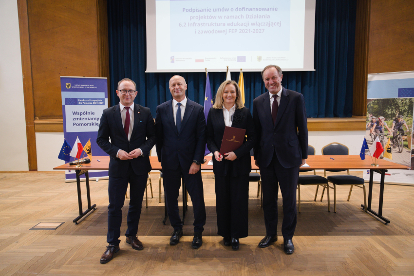 Marszałek Mieczysław Struk, wicemarszałek Marcin Skwierawski i dwie inne osoby prezentują podpisaną umowę