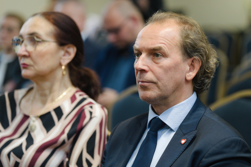 Osoby siedzą na sali podczas wydarzenia