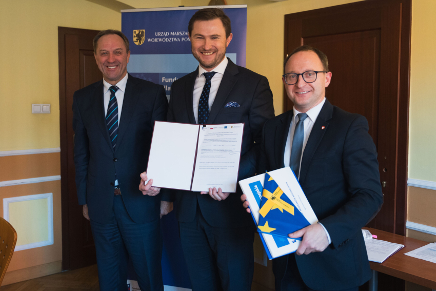 Trzy osoby prezentują podpisaną umowę, w tym marszałek Mieczysław Struk oraz wicemarszałek Marcin Skwierawski