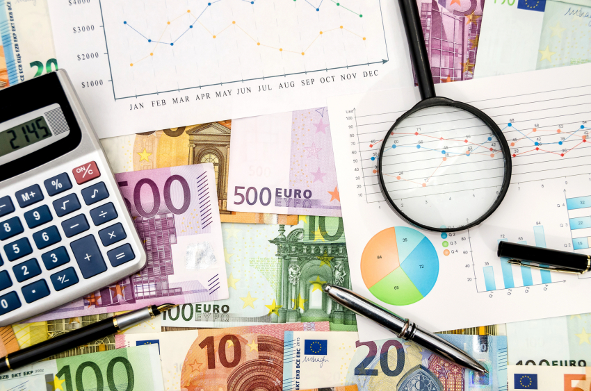 papiery, pieniądze, lupa i kalkulator leżą na stole