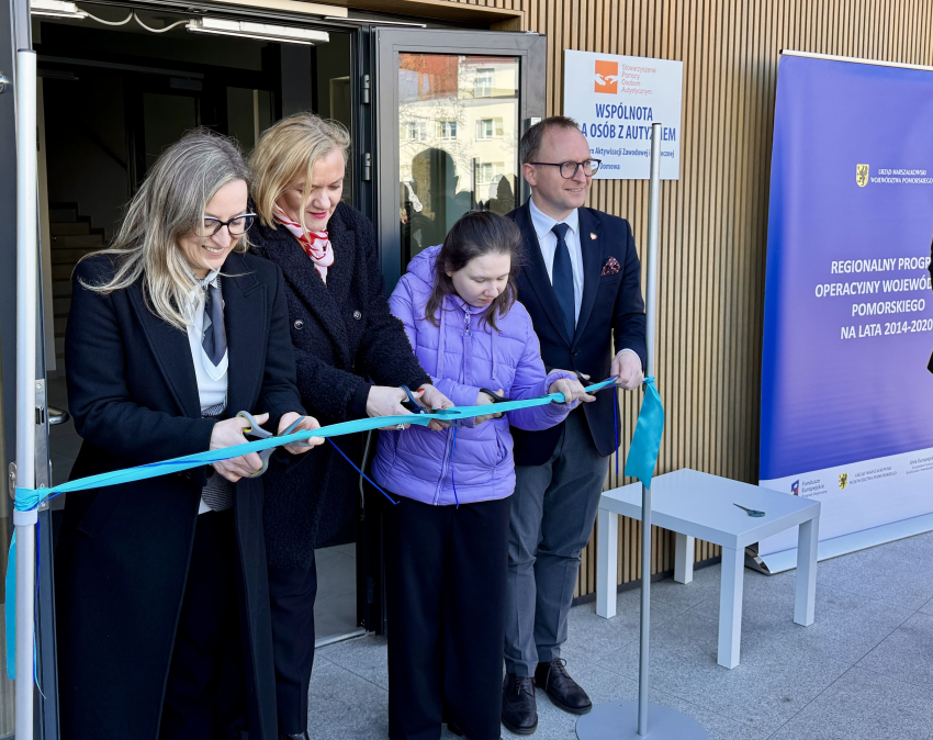 Wicemarszałek województwa pomorskiego Marcin Skwierawski oraz trzy inne osoby przecinają wstęgę przy otwarciu budynku wspólnoty