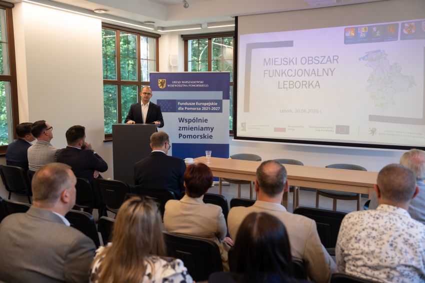 sala, ludzie, ekran z informacją o projekcie 