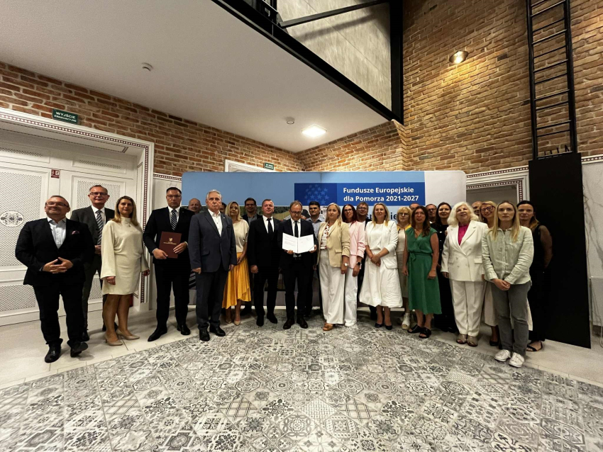 Zdjęcie przedstawia uczestników wydarzenia stojących w linii do uroczystego zdjęcia