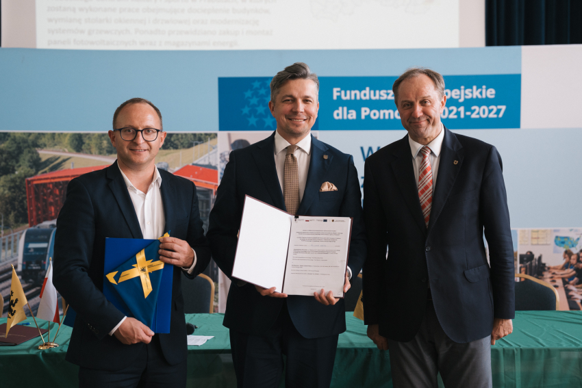 Marszałek Mieczysław Struk, wicemarszałek Marcin Skwierawski oraz przedstawiciel jednej z gmin prezentują podpisaną umowę oraz flagę Unii Europejskiej.