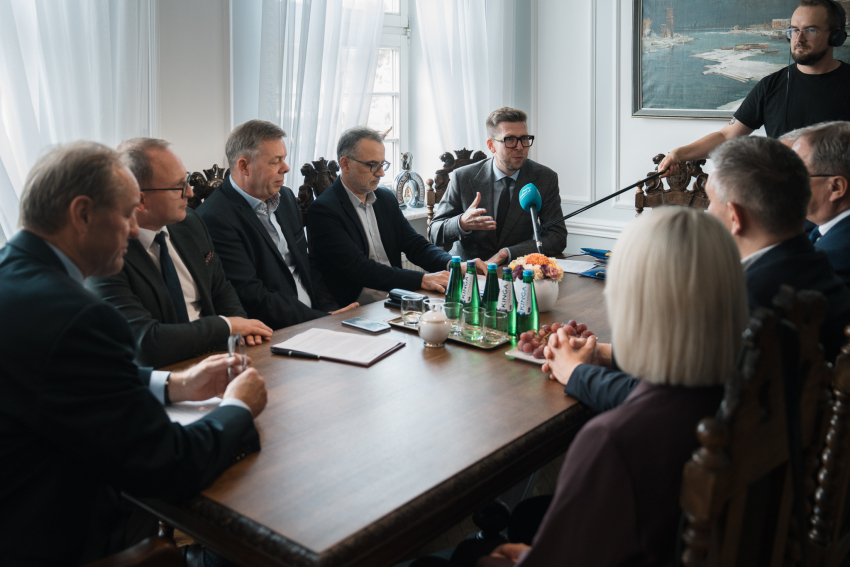 Foto: Łukasz Tokarczyk UMWP Przy stole siedzi dziewięciu uczestników wydarzenia, wśród nich marszałek Mieczysław Struk, wicemarszałek Marcin Skwierawski, dyrektor Departamentu Programów Regionalnych Jan Szymański, prezydent Starogardu Gdańskiego Janusz Stankowiak oraz wójt gminy Chmielno Michał Melibruda. Stoi również mężczyzna z mikrofonem z Radia Gdańsk