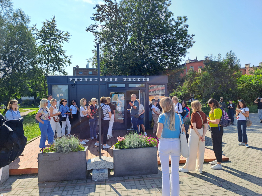 Grupa ludzi na tle lokalu w blaszanym kontenerze