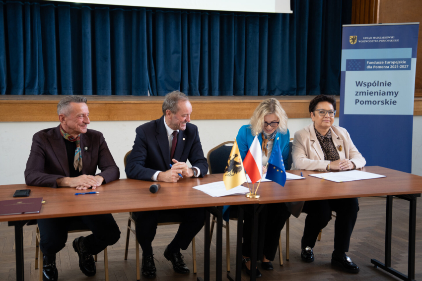 Marszałek Leszek Bonna oraz Mieczysław Struk. Siedzą przy stole. Po prawej dwie kobiety - przedstawicielki beneficjenta. Podpisują umowę. 