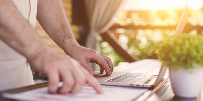 Dłonie na laptopie.