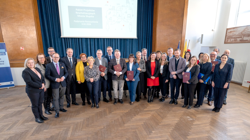 grupa osób przedstawia podpisaną Umowę