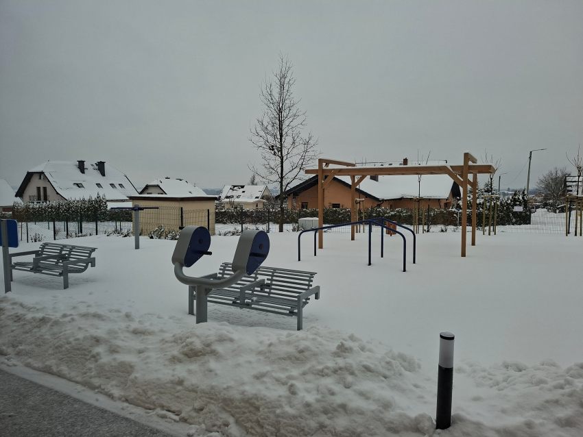 Park z ławeczkami i przyrządami do ćwiczeń na zewnątrz "Radosnej Przystani" w Sierakowicach