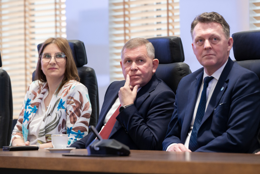 Trzech przedstawicieli lokalnych władz słucha prezentacji
