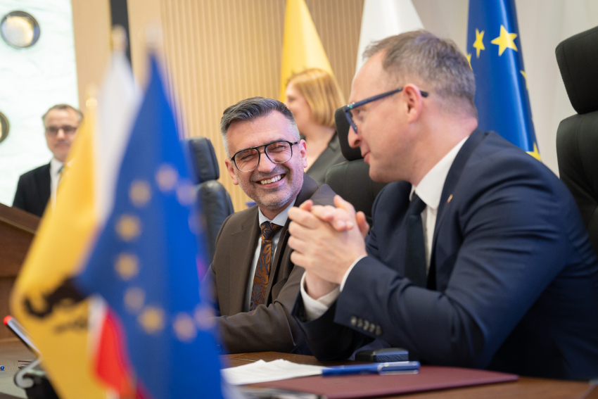 Od lewej: Burmistrz Czerska Burmistrz Czerska - Daniel Szpręga oraz wicemarszałek województwa pomorskiego Marcin Skwierawski uśmiechają się i rozmawiają przy stole prezydialnym