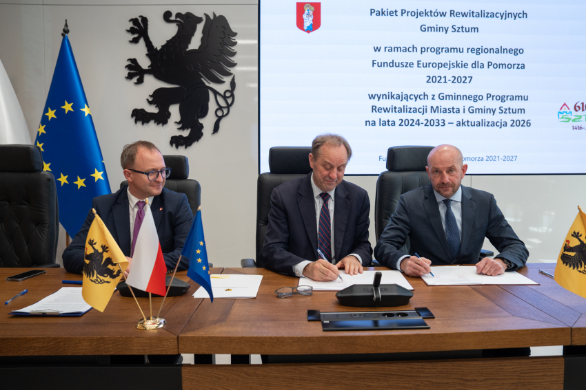 Marszałek Mieczysław Struk, wicemarszałek Marcin Skwierawski oraz przedstawiciel władz regionu siedzą przy stole prezydialnym i podpisują umowę