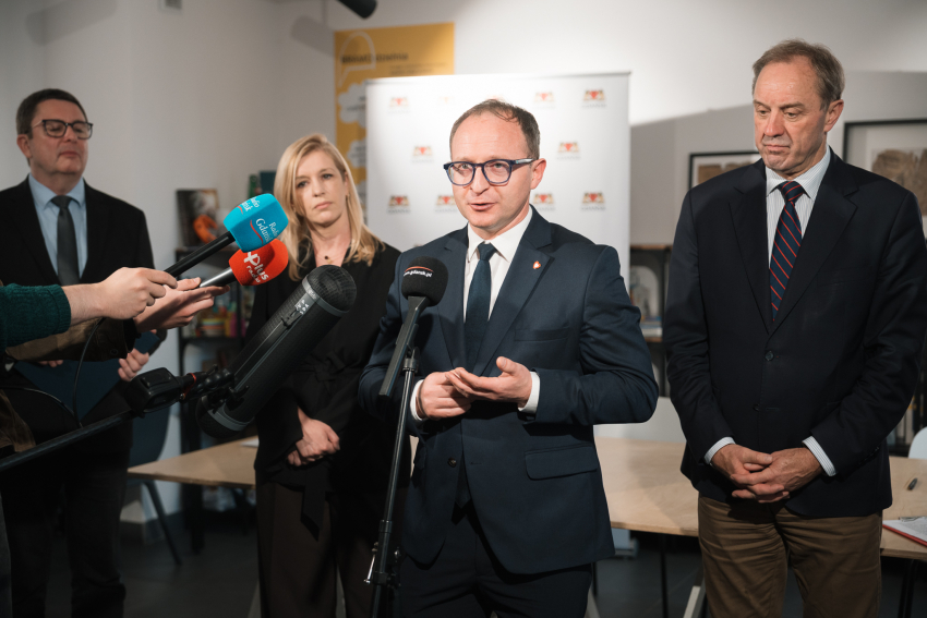 wicemarszałek Marcin Skwierawski udziela wywiadu do mikrofonu. Obok stoją wiceprezydent Gdańska Emilia Lodzińska  oraz marszałek Mieczysław Struk