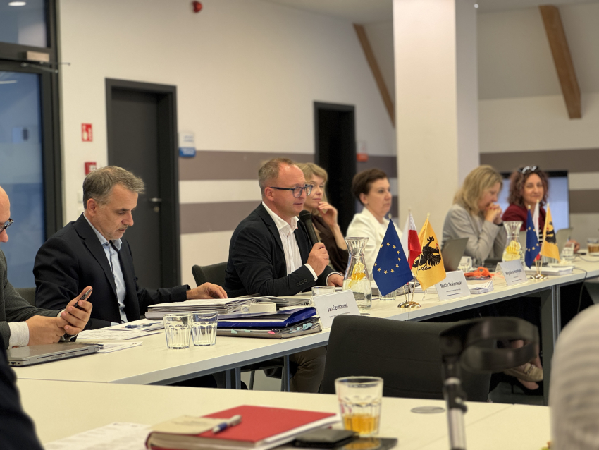 Przy stole prezydialnym siedzą, od lewej: Jan Szymański - dyrektor Departamentu Programów Regionalnych, prowadzący posiedzenie Marcin Skwierawski - wicemarszałek województwa pomorskiego, Magdalena Horodyska (Dyrekcja Generalna ds. Polityki Regionalnej i Miejskiej), Patrycja Szczygieł - zastępca dyrektora departamentu rozwoju regionalnego i przestrzennego, Agnieszka Surudo - zastępca dyrektora departamentu programów regionalnych oraz jeszcze jedna osoba
