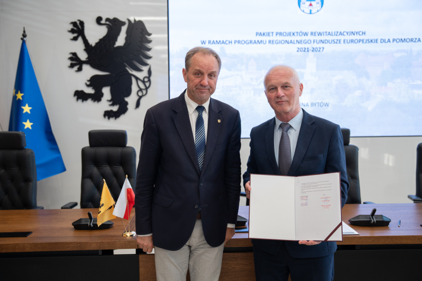 marszałek Mieczysław Struk oraz przedstawiciel lokalnych władz prezentują podpisane porozumienie i pozują do zdjęcia