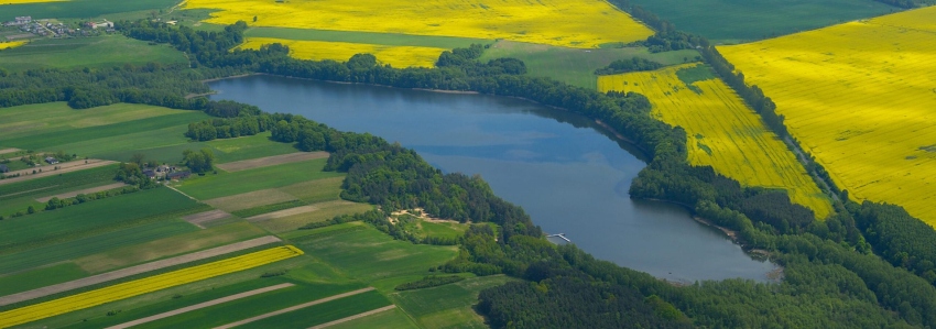 na zdjęciu jezioro, łąki i pola