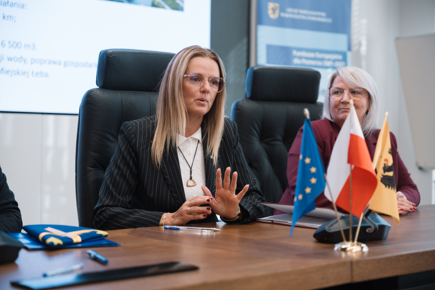 Dwie przedstawicielki władz lokalnych podpisują umowę o dofinansowanie przy stole prezydialnym