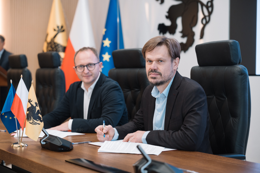 Wicemarszałek województwa pomorskiego oraz przedstawiciel Powiślańskiej Regionalna Agencji Zarządzania Energią podpisują umowę o dofinansowanie przy stole prezydialnym