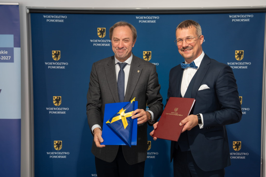 dwie osoby prezentują podpisaną umowę