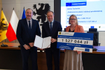 Marszałek i przedstawilciele gminy trzmaja czek informujący o dofinansowaniu