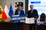 Marszałek i przedstawilciele gminy trzmaja czek informujący o dofinansowaniu