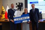 Marszałek i przedstawilciele gminy trzmaja czek informujący o dofinansowaniu