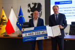 Marszałek i przedstawilciele gminy trzmaja czek informujący o dofinansowaniu