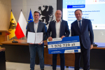Marszałek i przedstawilciele gminy trzmaja czek informujący o dofinansowaniu