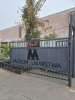 Metalowa brama z dużą literą M i napisem &amp;quot;Muzeum Lniarstwa&amp;quot;