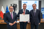 Marszałek Mieczysław Struk, wicemarszałek Marcin Skwierawski oraz przedstawiciel władz regionu pozują do uroczystego zdjęcia z podpisaną umową