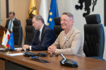 Wicemarszałek Leszek Bonna oraz marszałek Mieczysław Struk siedzą przy stole prezydialnym. W tle widać przy mównicy dyrektora departamentu programów regionalnych - Jana Szymańskiego