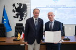 marszałek Mieczysław Struk oraz przedstawiciel lokalnych władz prezentują podpisane porozumienie i pozują do zdjęcia