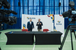 Burmistrz Rumi Michał Pasieczny oraz wicemarszałek województwa pomorskiego Marcin Skwierawski stoją przy stole prezydialnym i przemawiają do zebranych. Na drugim planie widać skierowane w ich stronę dwie kamery