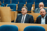 kilka osób siedzi i przysłuchuje się