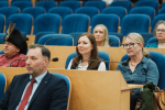 kilka osób siedzi i przysłuchuje się