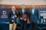 marszałkowie oraz przedstawiciel lokalnych władz pozują do zdjęcia z umową i flagą UE