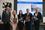 marszałek Mieczysław Struk, wicemarszałek Leszek Bonna oraz trzech przedstawicieli władz lokalnych pozuje do zdjęcia i prezentuje podpisaną umowę oraz flagę UE