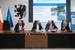 Wicemarszałek Marcin Skwierawski oraz trzech przedstawicieli władz lokalnych podpisują przy stole prezydialnym umowę o dofinansowanie