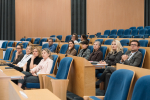 Grupa osób słucha wystąpień w trakcie konferencji