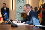 Wicemarszałek Marcin Skwierawski podpisuje przy stole prezydialnym umowę o dofinansowanie